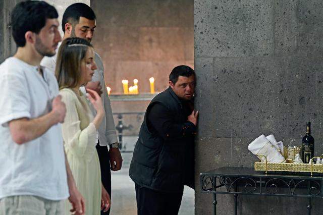 A man attends a baptizing ceremony in Echmiadzin, Armenia's ancient spiritual centre and the seat of the leader of the Armenian Apostolic Church, outside Yerevan, on April 18, 2026. (Photo by KAREN MINASYAN / AFP)