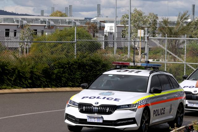 Police cars are parked outside the main gate of the purpose-built quarantine facility located on the outskirts of the Western Australian city of Perth on May 15, 2026, where passengers caught up in the MV Hondius hantavirus outbreak are being quarantined. A plane carrying six passengers caught up in the hantavirus outbreak on the MV Hondius cruise ship landed May 15 at a military airbase in western Australia, where they will immediately enter a strict three-week quarantine. (Photo by Antony DICKSON / AFP)