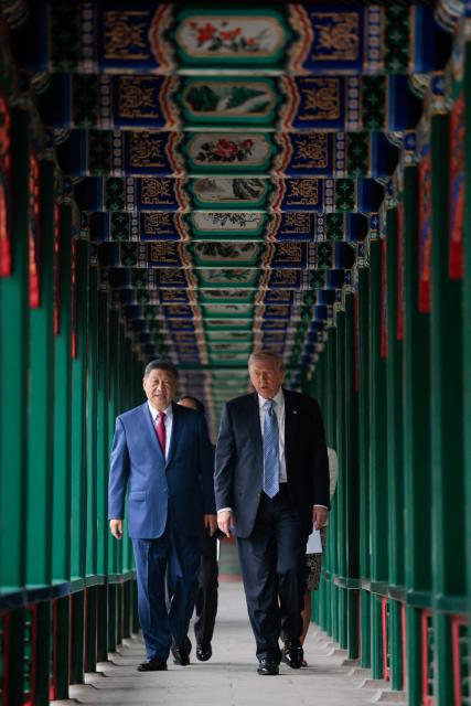 US President Donald Trump (R) walks with China’s President Xi Jinping (L) at Zhongnanhai Garden in Beijing on May 15, 2026. (Photo by Evan Vucci / POOL / AFP)