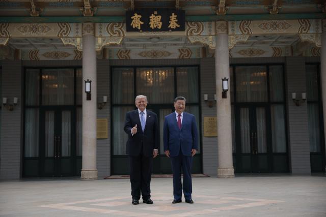 US President Donald Trump (L) poses for photos with China’s President Xi Jinping during a visit to Zhongnanhai Garden in Beijing on May 15, 2026. (Photo by Evan Vucci / POOL / AFP)