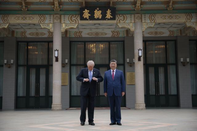 US President Donald Trump (L) prepares to pose for photos with China’s President Xi Jinping during a visit to Zhongnanhai Garden in Beijing on May 15, 2026. (Photo by Evan Vucci / POOL / AFP)