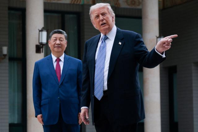 US President Donald Trump (R) gestures as he poses for photos with China’s President Xi Jinping during a visit to Zhongnanhai Garden in Beijing on May 15, 2026. (Photo by Evan Vucci / POOL / AFP)