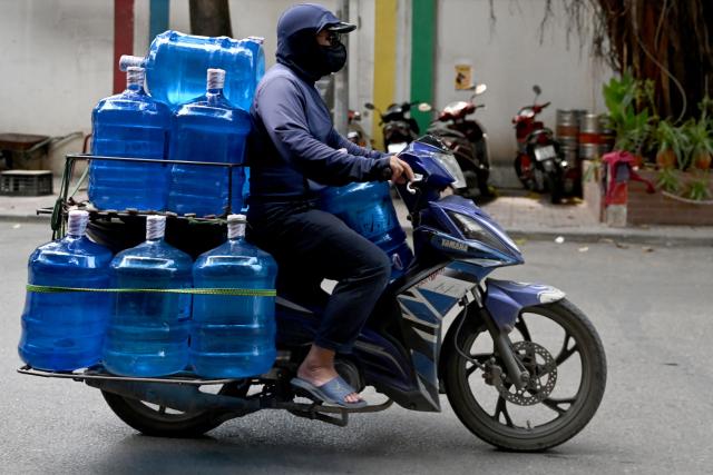 A man rides a motorbike carrying bottled drinking water in Hanoi on May 15, 2026. (Photo by Nhac NGUYEN / AFP)