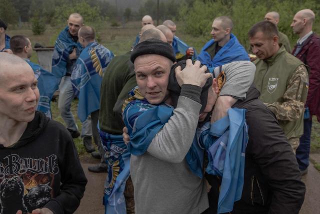Released Ukrainian prisoners of war (POWs) hug each other following a prisoner exchange at an undisclosed location, in the Chernihiv region on May 15, 2026, amid the Russian invasion of Ukraine. Russia and Ukraine exchanged 205 prisoners of war each on May 15, Moscow and Kyiv said, a week after US President Donald Trump announced a large swap would take place between the warring sides. (Photo by Roman PILIPEY / AFP)
