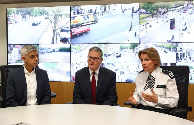 Britain's Prime Minister Keir Starmer (C) sits with Mayor of London Sadiq Khan (L) and Police Commander Clair Haynes beneath screens showing images of Whitehall from CCTV cameras located across London, as he meets with Metropolitan police officers to discuss operational planning ahead of this weekend's planned protests, in the Lambeth area of London on May 15, 2026. (Photo by Peter Nicholls / POOL / AFP)