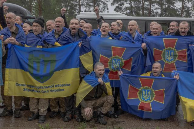 Released Ukrainian prisoners of war (POWs) react as they pose for a group photograph following a prisoner exchange at an undisclosed location, in the Chernihiv region on May 15, 2026, amid the Russian invasion of Ukraine. Russia and Ukraine exchanged 205 prisoners of war each on May 15, Moscow and Kyiv said, a week after US President Donald Trump announced a large swap would take place between the warring sides. (Photo by Roman PILIPEY / AFP)