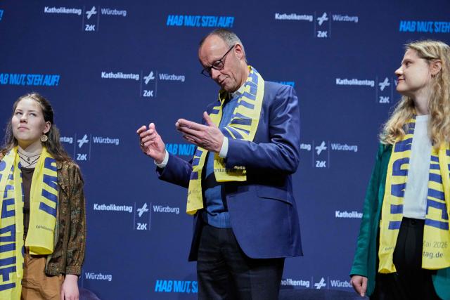 German Chancellor Friedrich Merz (C) arrives on stage to attend a panel discussion with young people during the “Deutscher Katholikentag”, a congress of the German Catholic people, in Wuerzburg, southern Germany, on May 15, 2026. (Photo by Matthias Schrader / POOL / AFP)