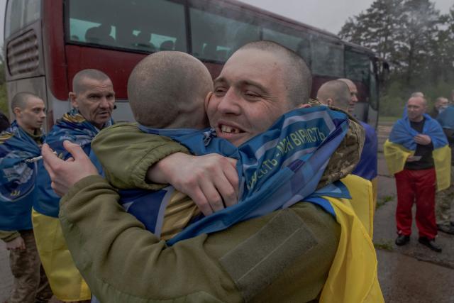 Released Ukrainian prisoners of war (POWs) embrace each other following a prisoner exchange at an undisclosed location, in the Chernihiv region on May 15, 2026, amid the Russian invasion of Ukraine. Russia and Ukraine exchanged 205 prisoners of war each on May 15, Moscow and Kyiv said, a week after US President Donald Trump announced a large swap would take place between the warring sides. (Photo by Roman PILIPEY / AFP)