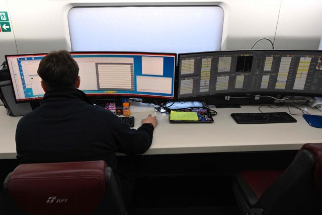 A technician works on screens aboard a diagnostic train named Diamante 2.0 which reaches a speed of 300 km/h and inspects high-speed lines, during a trip between Rome and Naples, on May 15, 2026. Diamante 2.0 is a train in the Rete Ferroviaria Italiana (RFI) fleet; the special train uses 98 cameras and over 200 sensors placed on the roof and on the trolleys near the wheels to monitor over 500 parameters to collect data on the infrastructure, useful for promptly eliminating possible causes of anomalies and for supporting the scheduling and planning of maintenance operations to be carried out. (Photo by Alberto PIZZOLI / AFP)