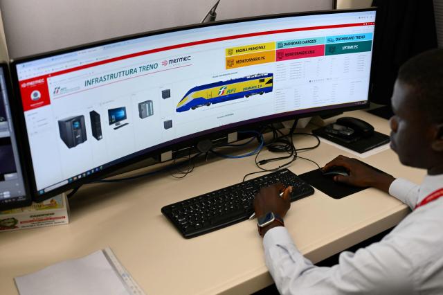 A technician works on screens aboard a diagnostic train named Diamante 2.0 which reaches a speed of 300 km/h and inspects high-speed lines, during a trip between Rome and Naples, on May 15, 2026. Diamante 2.0 is a train in the Rete Ferroviaria Italiana (RFI) fleet; the special train uses 98 cameras and over 200 sensors placed on the roof and on the trolleys near the wheels to monitor over 500 parameters to collect data on the infrastructure, useful for promptly eliminating possible causes of anomalies and for supporting the scheduling and planning of maintenance operations to be carried out. (Photo by Alberto PIZZOLI / AFP)