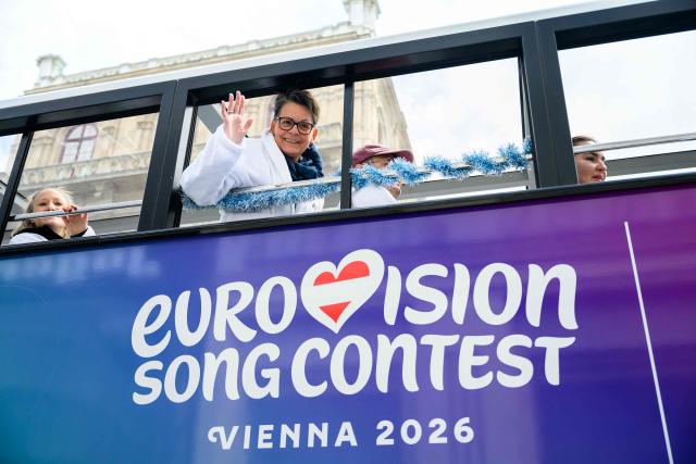 A member of the Eurovision Song Contest (ESC) Fan Club waves from a bus in Vienna, on May 15, 2026, on the eve of the 2026 Eurovision Song Contest (ESC) final. (Photo by MAX SLOVENCIK / APA / AFP) / Austria OUT