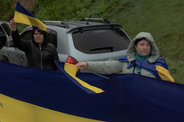 Onlookers gather along a road as they greet released Ukrainian prisoners of war (POWs) following a prisoner exchange, in the Chernihiv region on May 15, 2026, amid the Russian invasion of Ukraine. Russia and Ukraine exchanged 205 prisoners of war each on May 15, Moscow and Kyiv said, a week after US President Donald Trump announced a large swap would take place between the warring sides. (Photo by Roman PILIPEY / AFP)