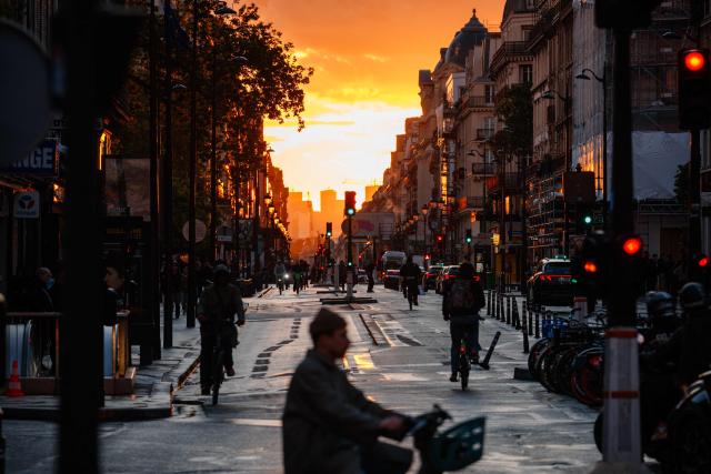 A man rides a bicycle Rue de Rivoli at sunset in Paris on May 14, 2026. (Photo by Dimitar DILKOFF / AFP)