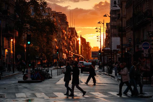 Pedestrians cross tue de Rivoli at sunset in Paris on May 14, 2026. (Photo by Dimitar DILKOFF / AFP)