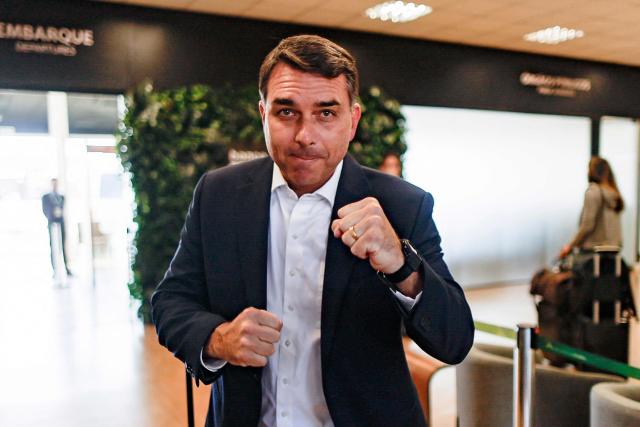 Brazilian Senator Flavio Bolsonaro, son of former President Jair Bolsonaro (2019-2022) and a pre-candidate for the presidency, poses for photographers upon arrival at the Presidente Juscelino Kubitschek International Airport in Brasilia on May 15, 2026. Brazilian presidential hopeful Flavio Bolsonaro denied wrongdoing on May 13, 2026 after the release of an audio recording in which he asks for money from a banker jailed over a multi-million dollar fraud scandal. (Photo by Sergio Lima / AFP)