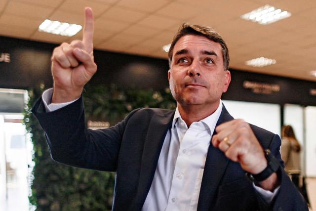 Brazilian Senator Flavio Bolsonaro, son of former President Jair Bolsonaro (2019-2022) and a pre-candidate for the presidency, poses for photographers upon arrival at the Presidente Juscelino Kubitschek International Airport in Brasilia on May 15, 2026. Brazilian presidential hopeful Flavio Bolsonaro denied wrongdoing on May 13, 2026 after the release of an audio recording in which he asks for money from a banker jailed over a multi-million dollar fraud scandal. (Photo by Sergio Lima / AFP)