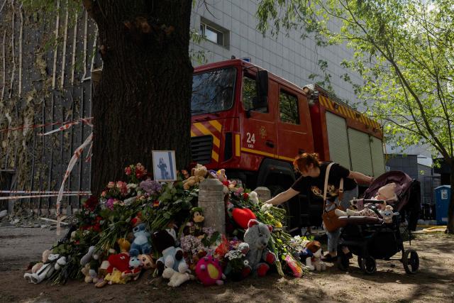 Local residents lay flowers at a makeshift memorial near a partially destroyed residential building in Kyiv on May 15, 2026, amid the Russian invasion of Ukraine. Ukraine's capital Kyiv was in mourning on May 15, 2026, after a Russian attack killed 24 people a day earlier, with President Volodymyr Zelensky denouncing Moscow's "brutal terror" as the two sides went ahead with an exchange of hundreds of captured soldiers. (Photo by Tetiana DZHAFAROVA / AFP)