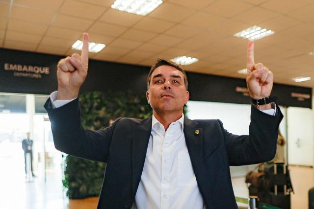 Brazilian Senator Flavio Bolsonaro, son of former President Jair Bolsonaro (2019-2022) and a pre-candidate for the presidency, poses for photographers upon arrival at the Presidente Juscelino Kubitschek International Airport in Brasilia on May 15, 2026. Brazilian presidential hopeful Flavio Bolsonaro denied wrongdoing on May 13, 2026 after the release of an audio recording in which he asks for money from a banker jailed over a multi-million dollar fraud scandal. (Photo by Sergio Lima / AFP)