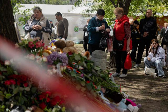 Local residents gather at a makeshift memorial near a partially destroyed residential building in Kyiv on May 15, 2026, amid the Russian invasion of Ukraine. Ukraine's capital Kyiv was in mourning on May 15, 2026, after a Russian attack killed 24 people a day earlier, with President Volodymyr Zelensky denouncing Moscow's "brutal terror" as the two sides went ahead with an exchange of hundreds of captured soldiers. (Photo by Tetiana DZHAFAROVA / AFP)