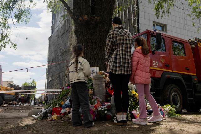 Local residents are standing at a makeshift memorial near a partially destroyed residential building in Kyiv on May 15, 2026, amid the Russian invasion of Ukraine. Ukraine's capital Kyiv was in mourning on May 15, 2026, after a Russian attack killed 24 people a day earlier, with President Volodymyr Zelensky denouncing Moscow's "brutal terror" as the two sides went ahead with an exchange of hundreds of captured soldiers. (Photo by Tetiana DZHAFAROVA / AFP)