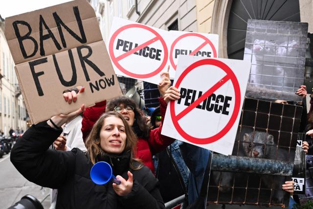 (FILES) Protestors hold signs reading "Ban fur" ahead of the Giorgio Armani womens's ready-to-wear Fall/Winter 2026 collection fashion show as part of the Milan Fashion Week, in Milan on March 1, 2026. On May 15, 2006, the organizing committee of Milan Fashion Week “urged” fashion brands to avoid using fur in their shows, a decision taken following lengthy discussions with NGOs. (Photo by Miguel MEDINA / AFP)
