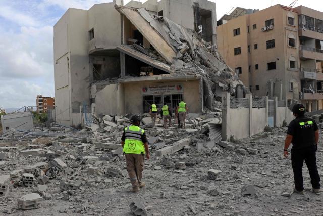 First responders inspect the destruction at the site of an Israeli airstrike that targeted the headquarters of a local NGO, in the southern coastal city of Tyre on May 15, 2026. Israel carried out new strikes in southern Lebanon that it said targeted the militant group Hezbollah on May 15, hours before the two countries' envoys were set to meet for a second day of peace talks in Washington. (Photo by Kawnat HAJU / AFP)
