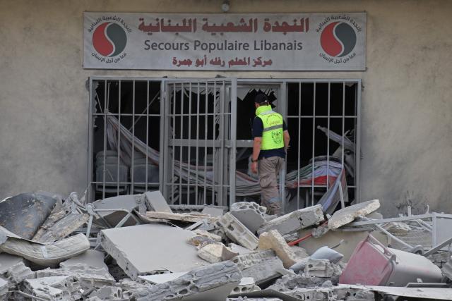 A first responder inspects the destruction at the site of an Israeli airstrike that targeted the headquarters of a local NGO, in the southern coastal city of Tyre on May 15, 2026. Israel carried out new strikes in southern Lebanon that it said targeted the militant group Hezbollah on May 15, hours before the two countries' envoys were set to meet for a second day of peace talks in Washington. (Photo by Kawnat HAJU / AFP)