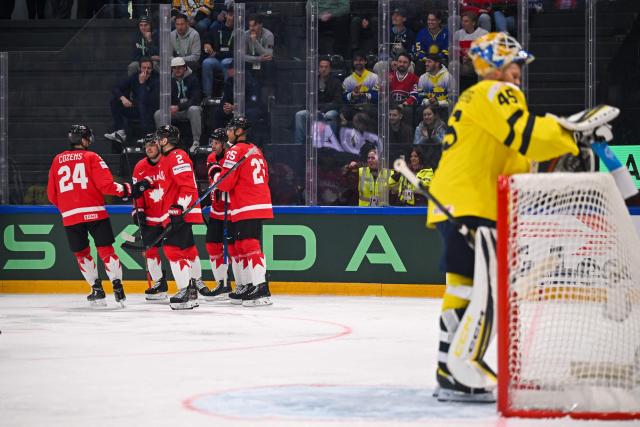 Canada’s players celebrates their team's first goal against Sweden's goalkeeper #45 Magnus Hellberg during the groupe B match between Canada and Sweden at the IIHF Ice Hockey Men's World Championship at BFC Arena, in Fribourg on May 15, 2026. (Photo by Fabrice COFFRINI / AFP)