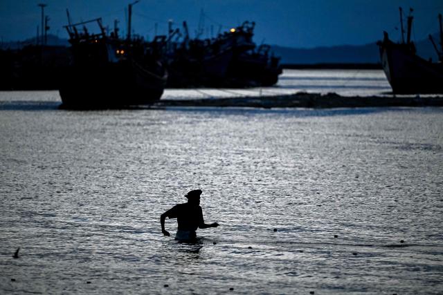 A fisherman catches fish at a beach in Banda Aceh on May 15, 2026. (Photo by Chaideer MAHYUDDIN / AFP)