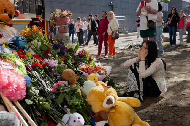 A teenage girl is crying at a makeshift memorial near a partially destroyed residential building in Kyiv on May 15, 2026, amid the Russian invasion of Ukraine. Local residents gather at a makeshift memorial near a partially destroyed residential building in Kyiv on May 15, 2026, amid the Russian invasion of Ukraine. (Photo by Tetiana DZHAFAROVA / AFP)