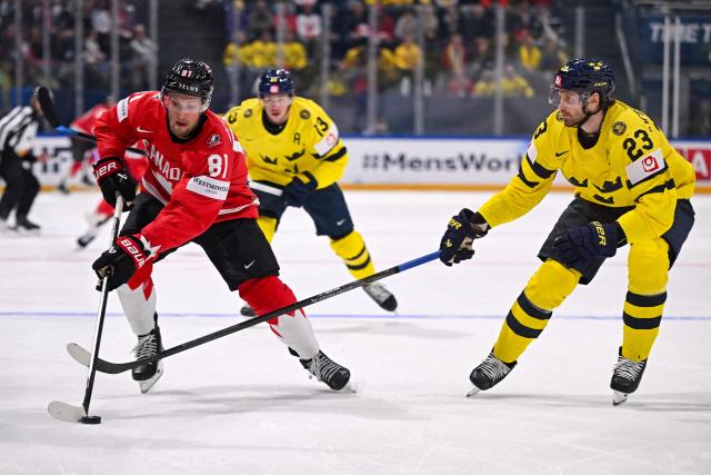 Canada’s forward #81 Dylan Holloway (L) fights for the puck with Sweden's defender #23 Oliver Ekman-Larsson during the IIHF Ice Hockey Men's World Championship first round group B ice hockey match between Canada and Sweden at the BFC Arena, in Fribourg, Switzerland on May 15, 2026. (Photo by Fabrice COFFRINI / AFP)