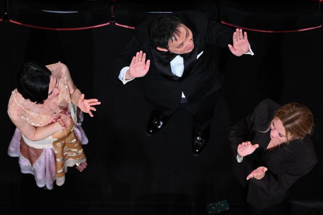 Japanese director and screenwriter Ryusuke Hamaguchi (C), Belgian actress Virginie Efira (R) acknowledge applause after the screening of the film "Soudain" (All of a Sudden) at the 79th edition of the Cannes Film Festival in Cannes, southern France on May 15, 2026. (Photo by Antonin THUILLIER / AFP)