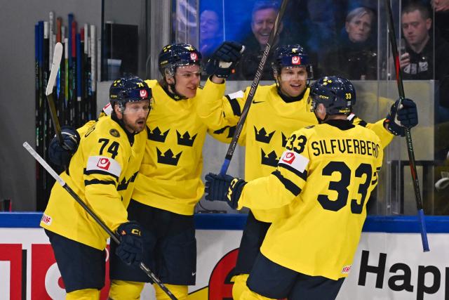 Sweden's forward #74 Rasmus Asplund (L) and Sweden's forward #33 Jakob Silfverberg (R) celebrate with teammates after scoring their team's first goal during the IIHF Ice Hockey Men's World Championship first round group B ice hockey match between Canada and Sweden at the BFC Arena, in Fribourg, Switzerland on May 15, 2026. (Photo by Fabrice COFFRINI / AFP)