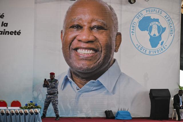 An Ivorian gendarme officer takes selfie next to former Ivorian President and Chairman of the African People's Party of Ivory Coast (PPA-CI) Laurent Gbagbo during the Party's 1st Congress closing ceremony in Abidjan on May 15, 2026. (Photo by Issouf SANOGO / AFP)