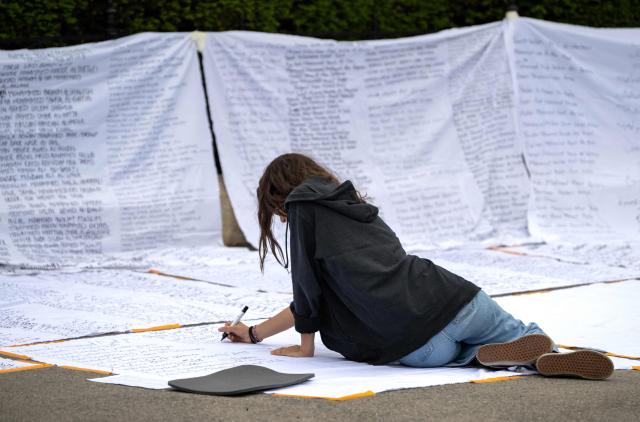 An activist is seen during an action to write down names of Palestinians, on the sidelines of a pro-Palestinian demonstration under the motto 'Song Protest Vienna 2026 - No Stage for Genocide' against Israel's participation in the Eurovision Song Contest (ESC), in Vienna, Austria, on May 15, 2026. (Photo by Joe Klamar / AFP)