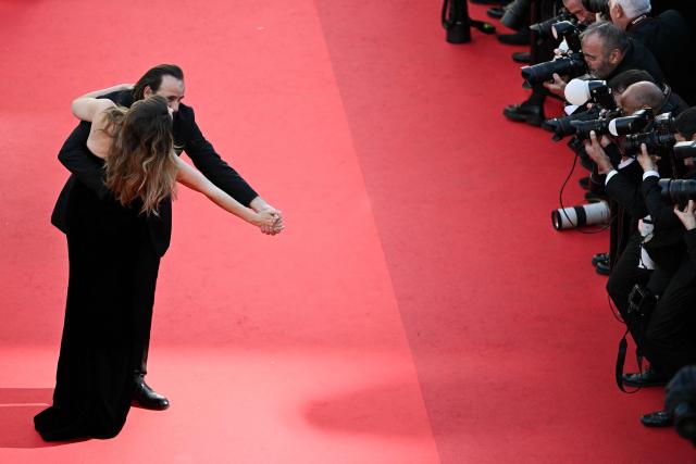 French actress and model Laetitia Casta and French actor Vincent Macaigne dance on the red carpet as they arrive for the screening of the film "Karma" at the 79th edition of the Cannes Film Festival in Cannes, southern France on May 15, 2026. (Photo by Antonin THUILLIER / AFP)