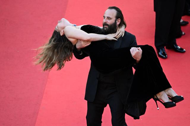 French actor Vincent Macaigne carries French actress and model Laetitia Casta on the red carpet as they arrive for the screening of the film "Karma" at the 79th edition of the Cannes Film Festival in Cannes, southern France on May 15, 2026. (Photo by Antonin THUILLIER / AFP)