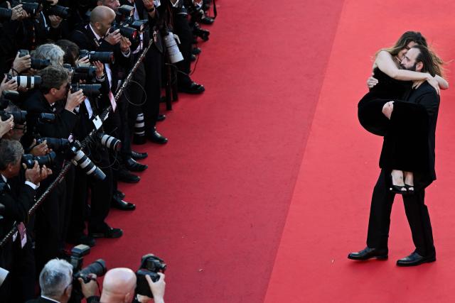 French actor Vincent Macaigne carries French actress and model Laetitia Casta on the red carpet as they arrive for the screening of the film "Karma" at the 79th edition of the Cannes Film Festival in Cannes, southern France on May 15, 2026. (Photo by Antonin THUILLIER / AFP)
