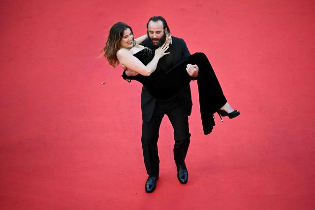 French actor Vincent Macaigne carries French actress and model Laetitia Casta on the red carpet as they arrive for the screening of the film "Karma" at the 79th edition of the Cannes Film Festival in Cannes, southern France on May 15, 2026. (Photo by Antonin THUILLIER / AFP)
