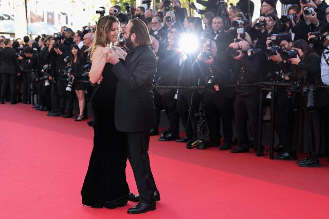 French actress and model Laetitia Casta and French actor Vincent Macaigne dance on the red carpet as they arrive for the screening of the film "Karma" at the 79th edition of the Cannes Film Festival in Cannes, southern France on May 15, 2026. (Photo by Thibaud MORITZ / AFP)