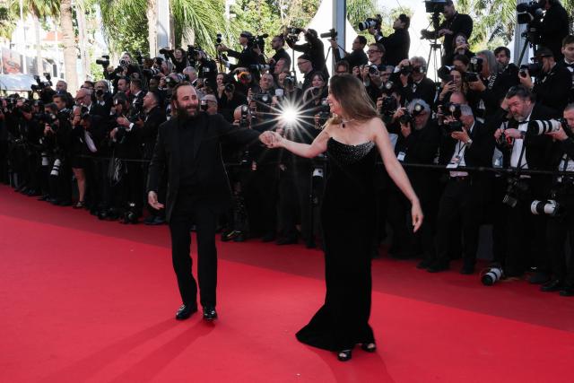 French actress and model Laetitia Casta and French actor Vincent Macaigne dance on the red carpet as they arrive for the screening of the film "Karma" at the 79th edition of the Cannes Film Festival in Cannes, southern France on May 15, 2026. (Photo by Thibaud MORITZ / AFP)