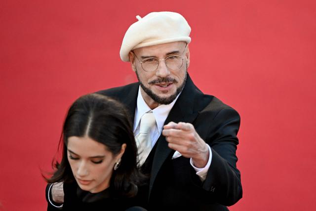 US actress Ella Bleu Travolta and US director, screenwriter and writer John Travolta arrives for the screening of the film "Propeller One-Way Night Coach" at the 79th edition of the Cannes Film Festival in Cannes, southern France on May 15, 2026. (Photo by Antonin THUILLIER / AFP)