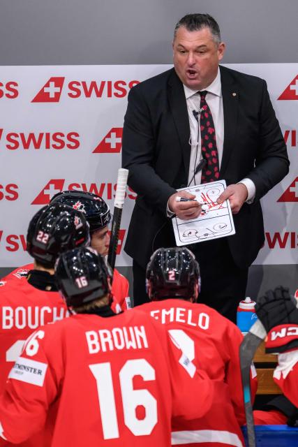 Canada’s head coach Misha Donskov (C) gestures as he speaks to his players during the IIHF Ice Hockey Men's World Championship first round group B ice hockey match between Canada and Sweden at the BFC Arena, in Fribourg, Switzerland on May 15, 2026. (Photo by Fabrice COFFRINI / AFP)