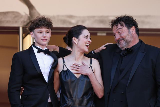 French actress Marion Cotillard (C) and her son French actor Marcel Canet (L) and French actor Denis Menochet arrive for the screening of the film "Karma" at the 79th edition of the Cannes Film Festival in Cannes, southern France on May 15, 2026. (Photo by Sameer AL-DOUMY / AFP)