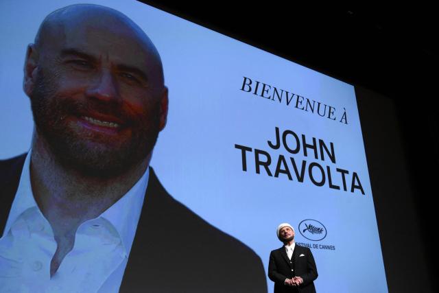 US director, screenwriter and writer John Travolta receives an honourary lifetime achievement Palm d'Or award prior to the screening of the film "Propeller One-Way Night Coach" at the 79th edition of the Cannes Film Festival in Cannes, southern France on May 15, 2026. (Photo by Olivier CHASSIGNOLE / AFP)