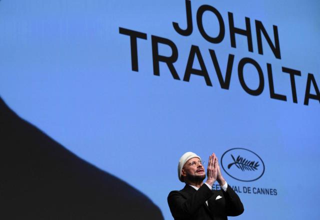 US director, screenwriter and writer John Travolta receives an honourary lifetime achievement Palm d'Or award prior to the screening of the film "Propeller One-Way Night Coach" at the 79th edition of the Cannes Film Festival in Cannes, southern France on May 15, 2026. (Photo by Olivier CHASSIGNOLE / AFP)