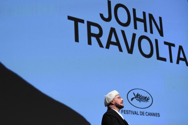 US director, screenwriter and writer John Travolta receives an honourary lifetime achievement Palm d'Or award prior to the screening of the film "Propeller One-Way Night Coach" at the 79th edition of the Cannes Film Festival in Cannes, southern France on May 15, 2026. (Photo by Olivier CHASSIGNOLE / AFP)