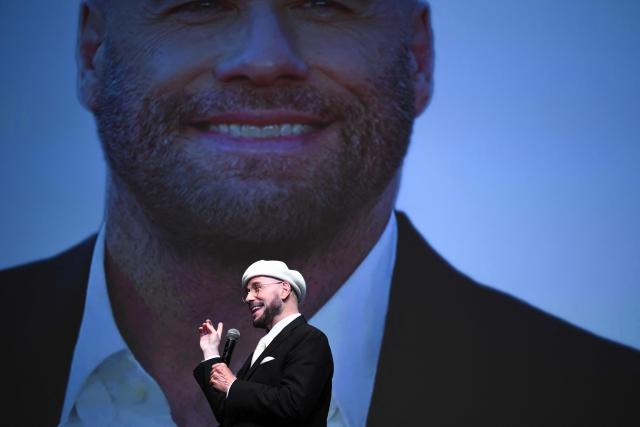 US director, screenwriter and writer John Travolta receives an honourary lifetime achievement Palm d'Or award prior to the screening of the film "Propeller One-Way Night Coach" at the 79th edition of the Cannes Film Festival in Cannes, southern France on May 15, 2026. (Photo by Olivier CHASSIGNOLE / AFP)
