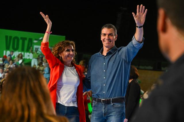 Spain's Prime Minister Pedro Sanchez (L) waves with Maria Jesus Montero, the Spanish Socialists Party (PSOE) candidate for President of Andalusia, during the closing campaign rally for Andalusia regional elections in Seville on May 15, 2026. The Socialists of Prime Minister Pedro Sanchez face a key electoral challenge May 16, 2026 in Andalusia, Spain's most populous region, following a string of defeats to the right wing a year before the general election. (Photo by CRISTINA QUICLER / AFP)
