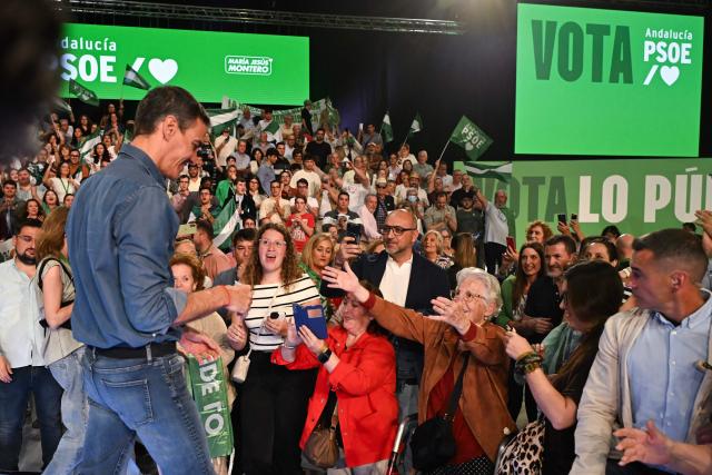 Spain's Prime Minister Pedro Sanchez approaches a woman after delivering a speech at the Spanish Socialists Party (PSOE) closing campaign rally for Andalusia regional elections in Seville on May 15, 2026. The Socialists of Prime Minister Pedro Sanchez face a key electoral challenge May 16, 2026 in Andalusia, Spain's most populous region, following a string of defeats to the right wing a year before the general election. (Photo by CRISTINA QUICLER / AFP)
